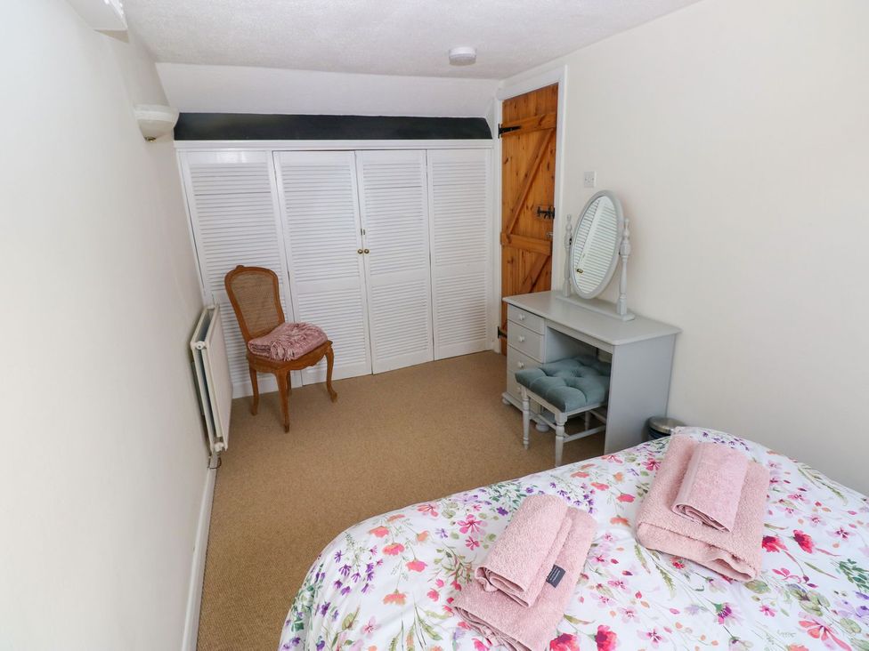 A bedroom with a bed and dressing table at The Stable in Haverfordwest