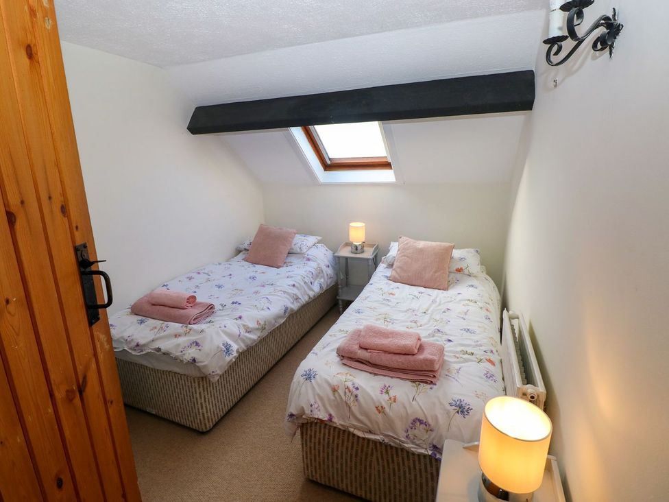 A bedroom with two beds and a lamp at The Stable in Haverfordwest