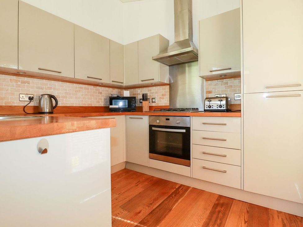 A kitchen with appliances and wooden countertops at 7 Stonerush Valley in Looe