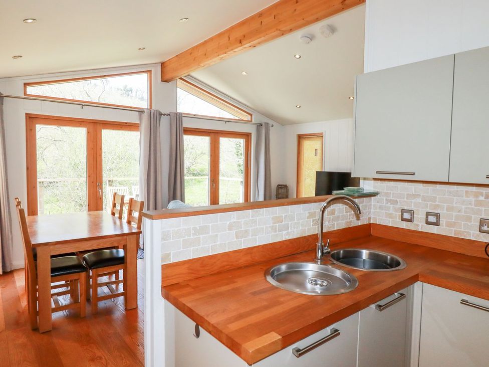 A kitchen with a table and chairs at 7 Stonerush Valley in Looe
