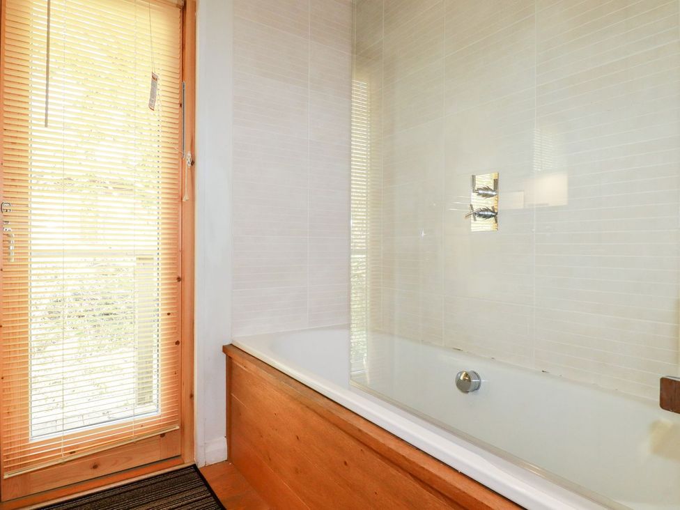 A bathroom with a bathtub and a window at 7 Stonerush Valley Looe