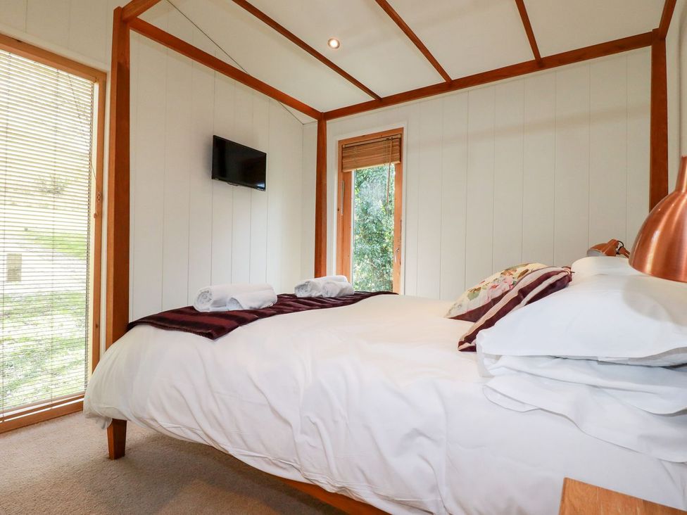 A bedroom with a bed and television at 7 Stonerush Valley Looe