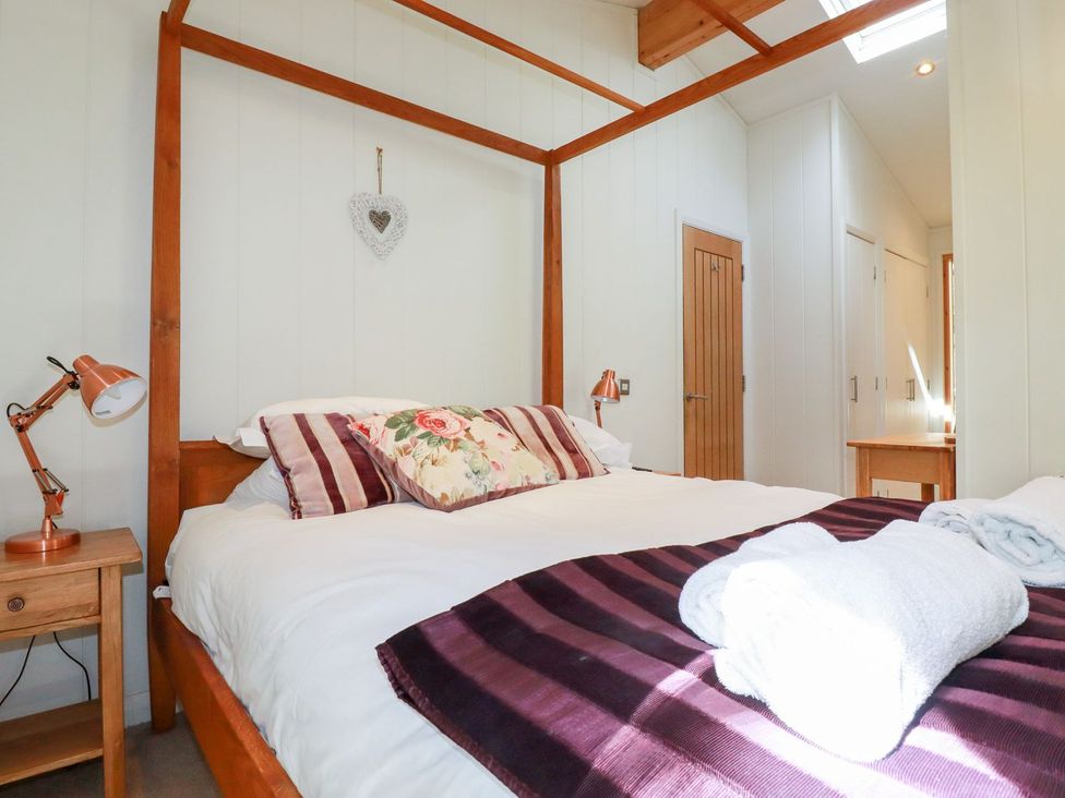 A bedroom with a bed and table lamp at 7 Stonerush Valley in Looe