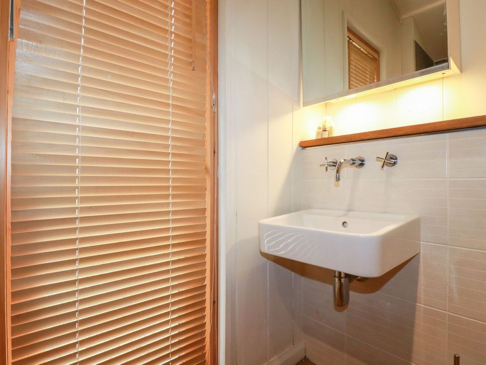 A bathroom with a sink and mirror at 7 Stonerush Valley in Looe
