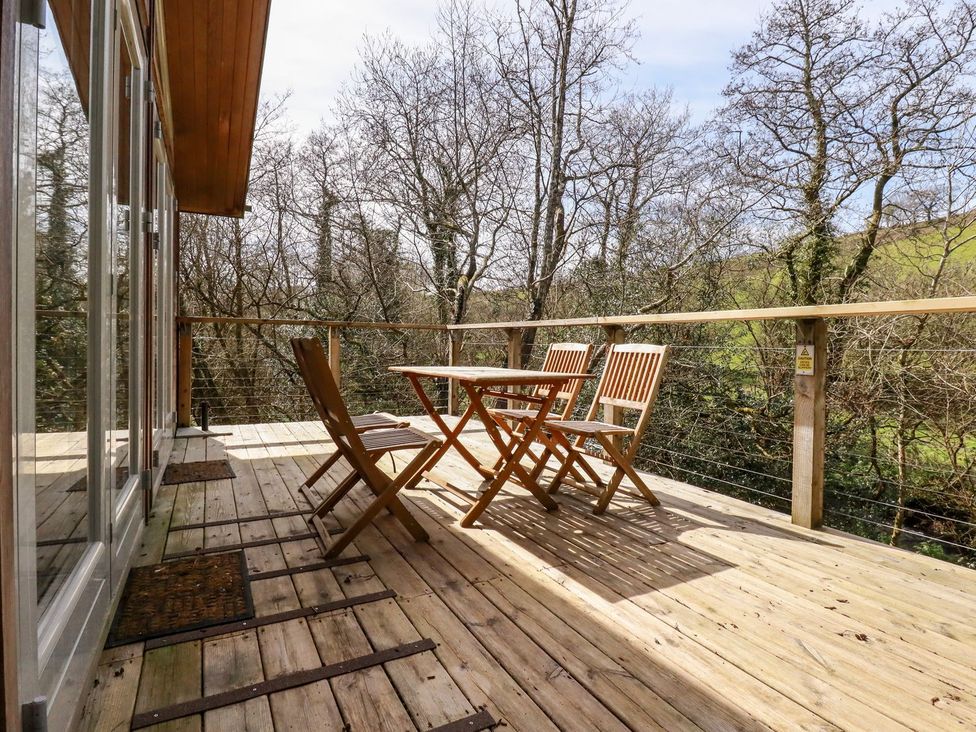 An outdoor deck with a table and chairs at 7 Stonerush Valley in Looe