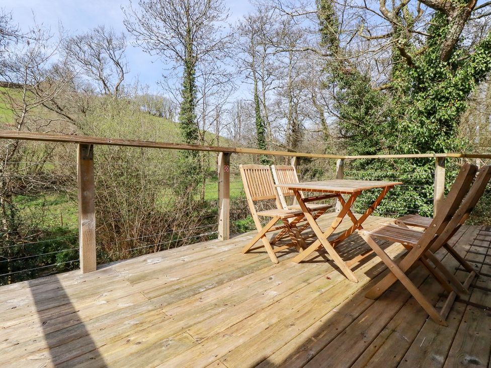 A wooden deck with a table and chairs at 7 Stonerush Valley Looe