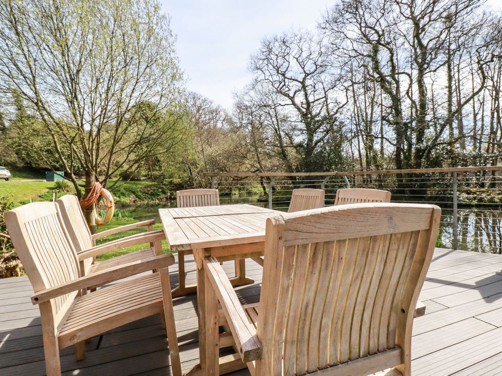 An outdoor dining area with a wooden table and chairs at 7 Stonerush Valley Looe
