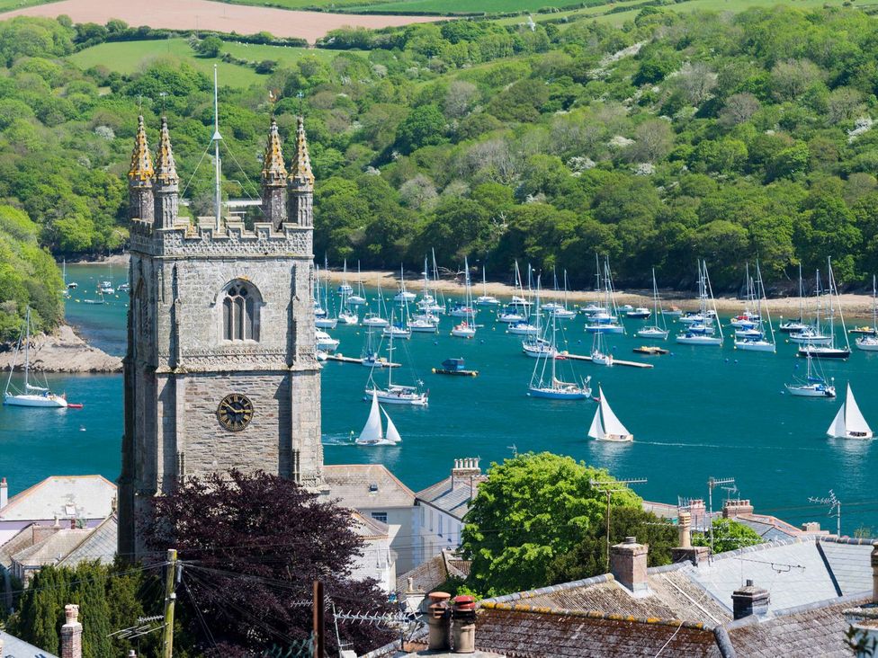 A church tower overlooking boats in the water at 7 Stonerush Valley in Lanreath