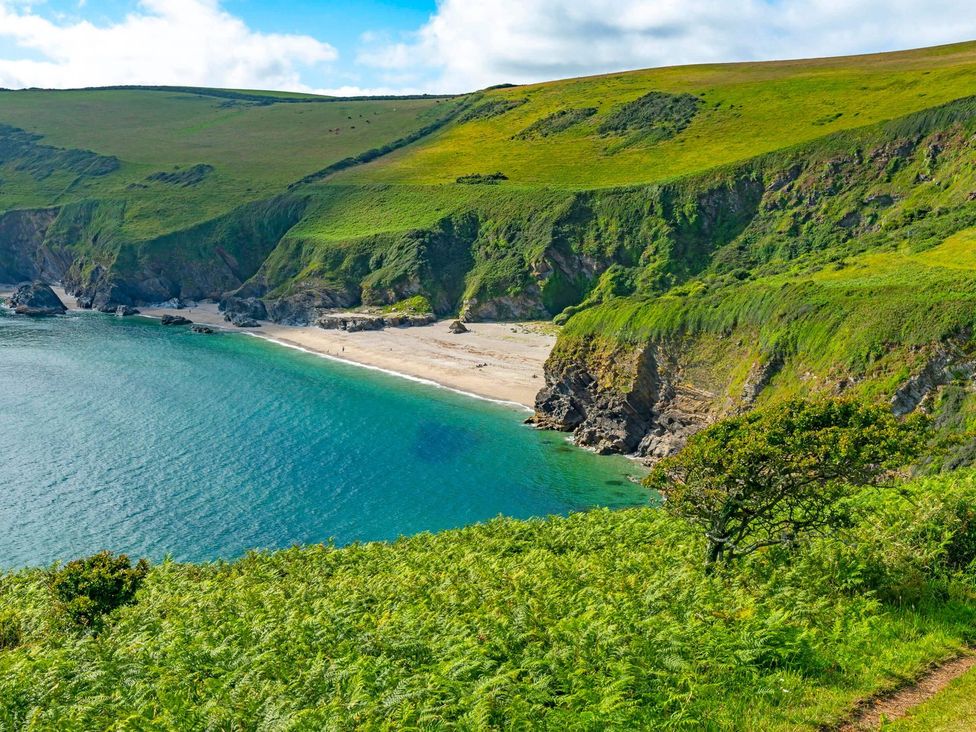 A beach with cliffs and greenery at 7 Stonerush Valley, Lanreath