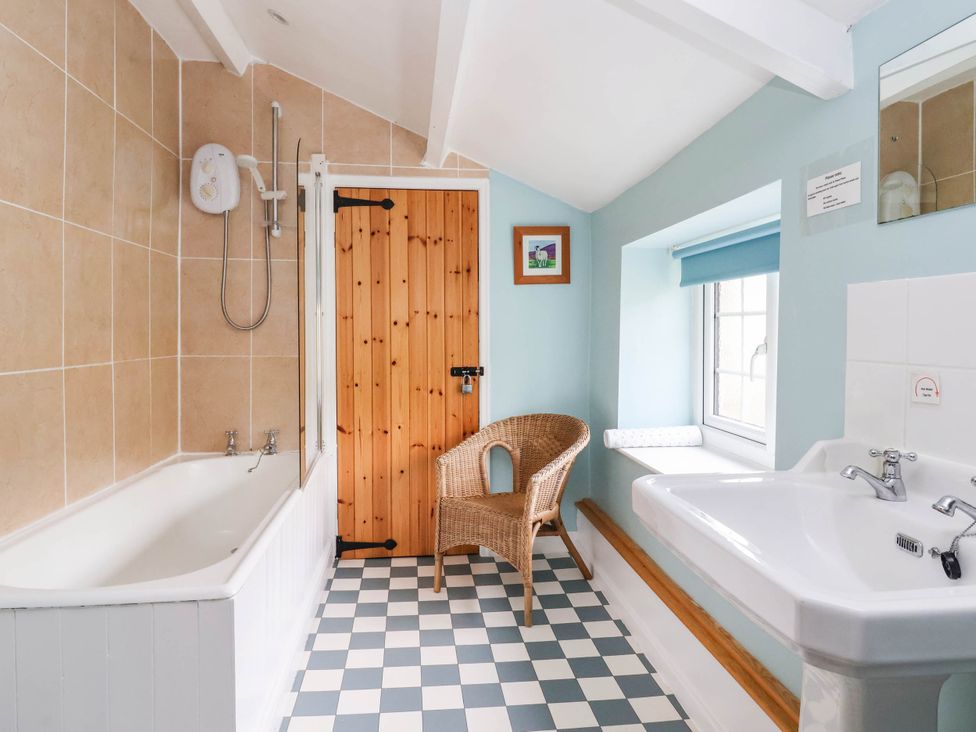 A bathroom with a bathtub, shower, sink, and chair at South View, Richmond