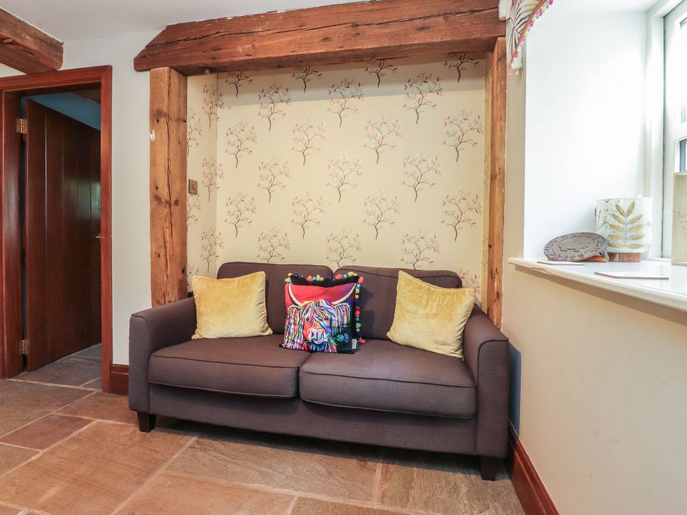 A living room with a sofa and cushions at The Shippon in Ormskirk