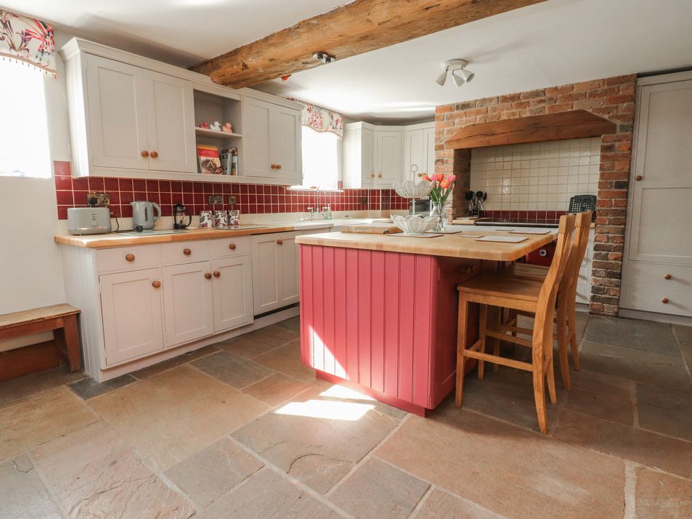 A kitchen with cabinets and an island at The Shippon in Ormskirk