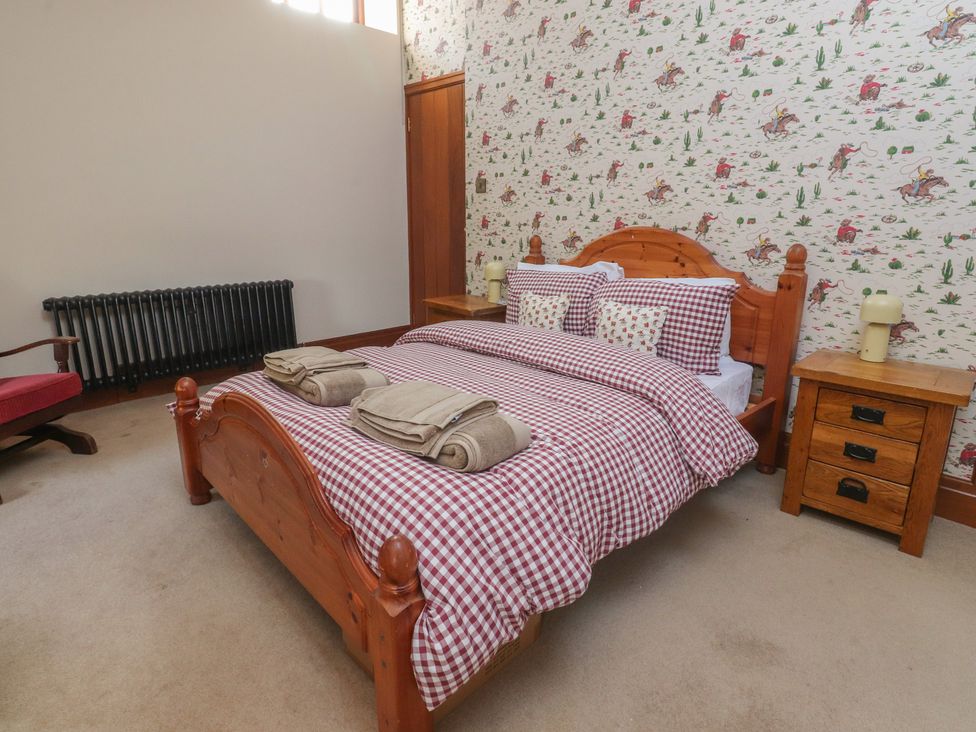 A bedroom with a bed and bedside table at The Shippon in Ormskirk