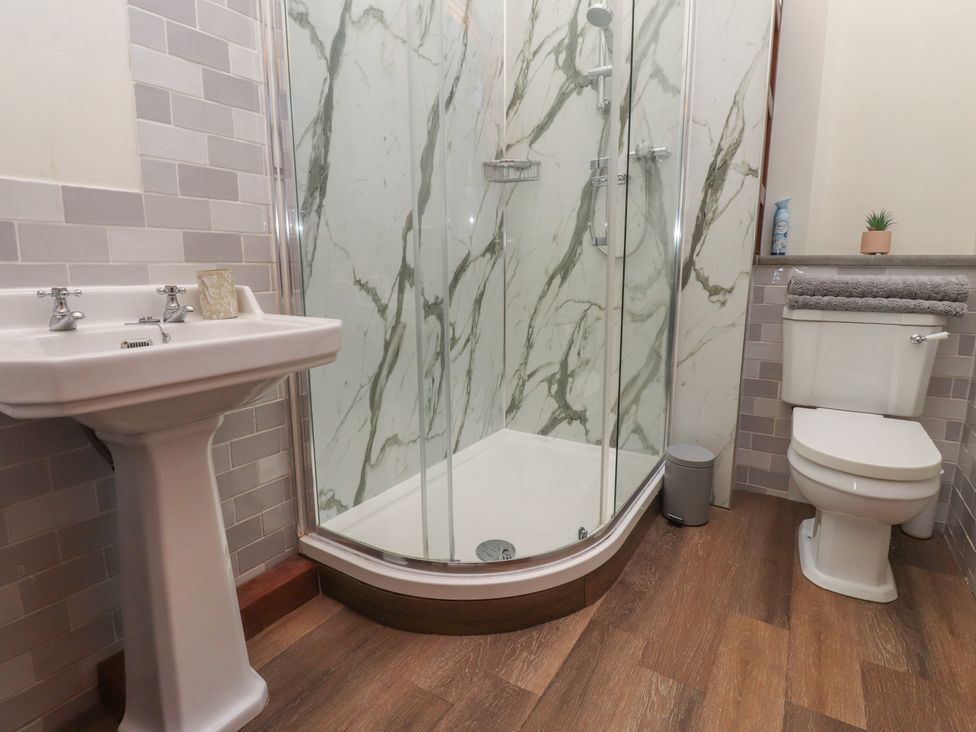 A bathroom with a shower, sink, and toilet at The Shippon in Ormskirk