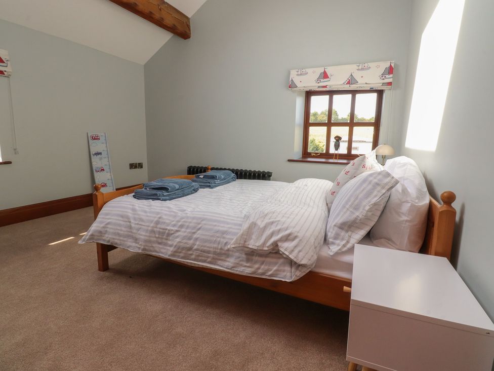 A bedroom with a bed and bedside table at The Shippon in Ormskirk