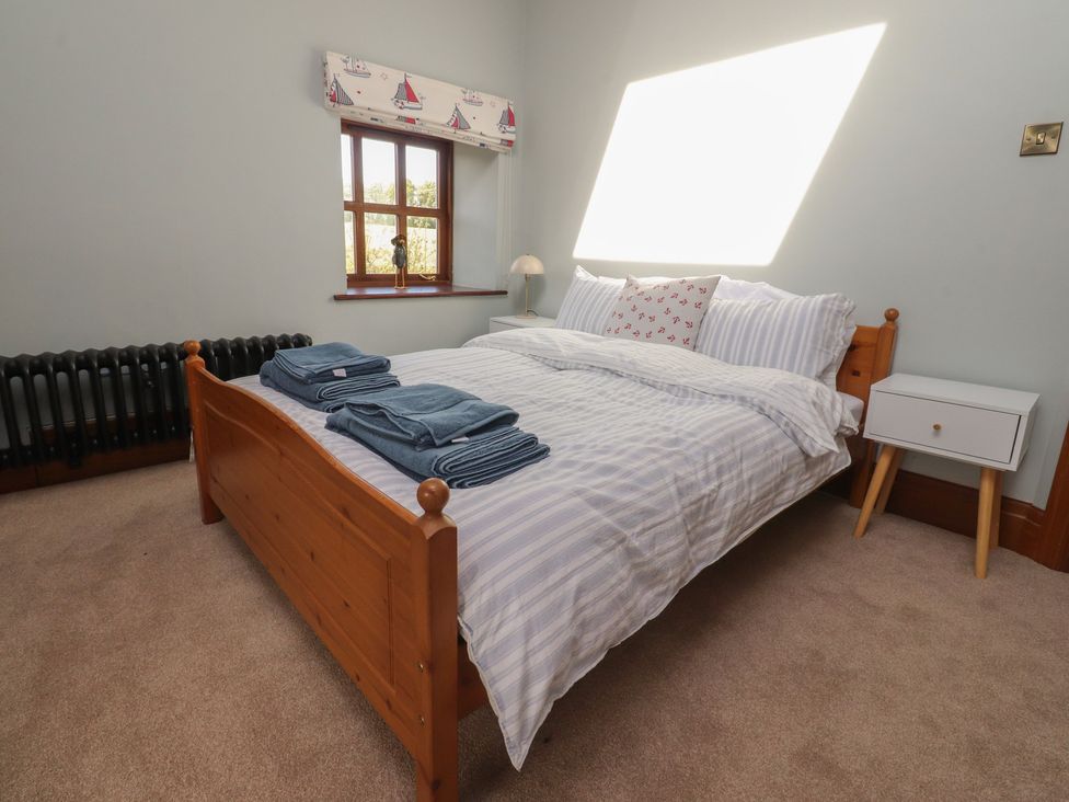 A bedroom with a bed and a bedside table at The Shippon in Ormskirk