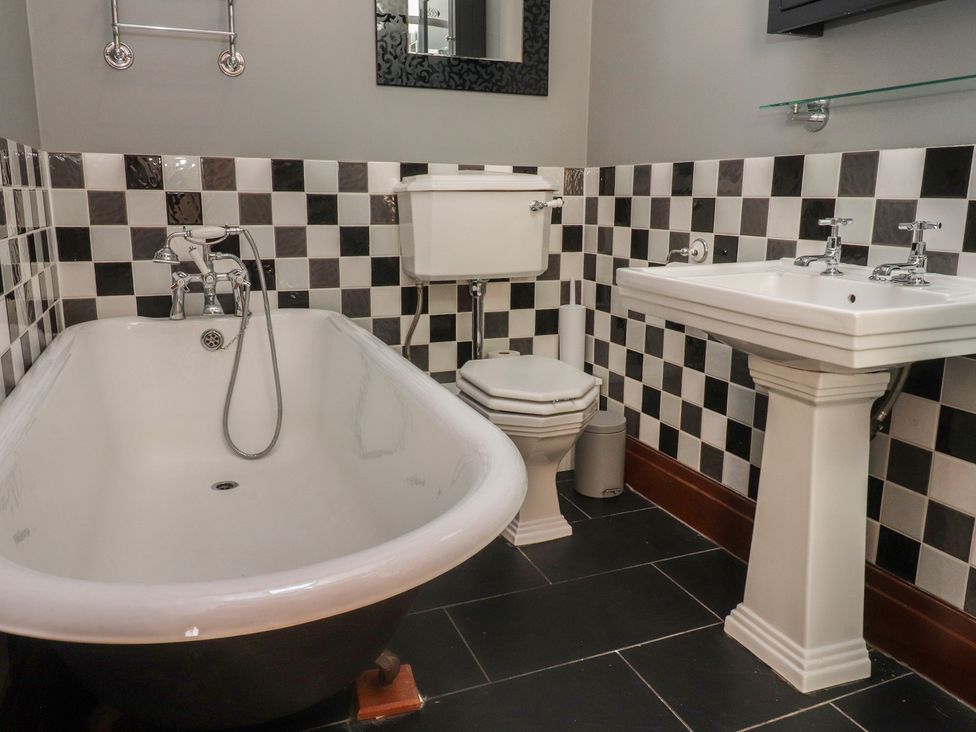 A bathroom with a bathtub, toilet, and sink at The Shippon in Ormskirk