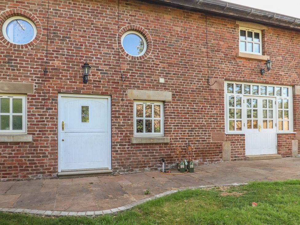 An exterior view of a brick building with doors and windows at The Shippon in Ormskirk