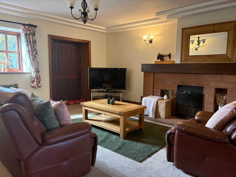 A living room with a sofa and television at The Shippon in Burscough