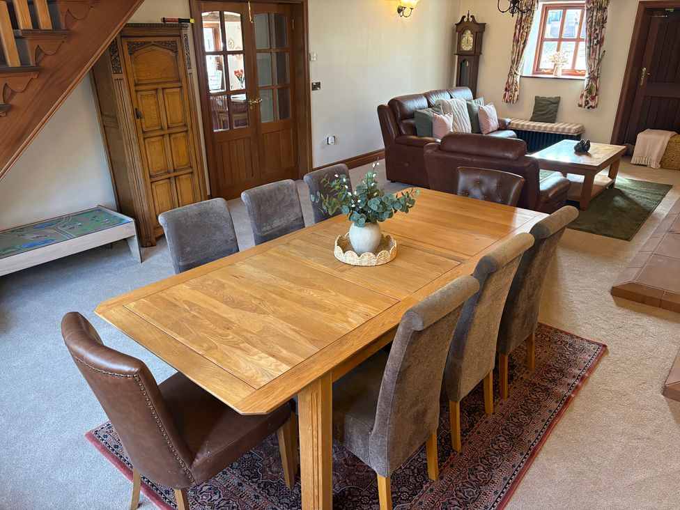 A dining table with chairs and a sofa at The Shippon in Burscough