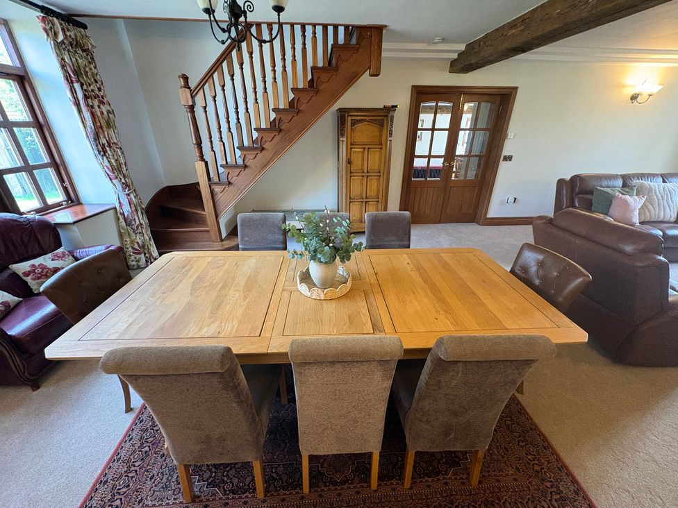 A dining room with a wooden table and chairs at The Shippon in Burscough