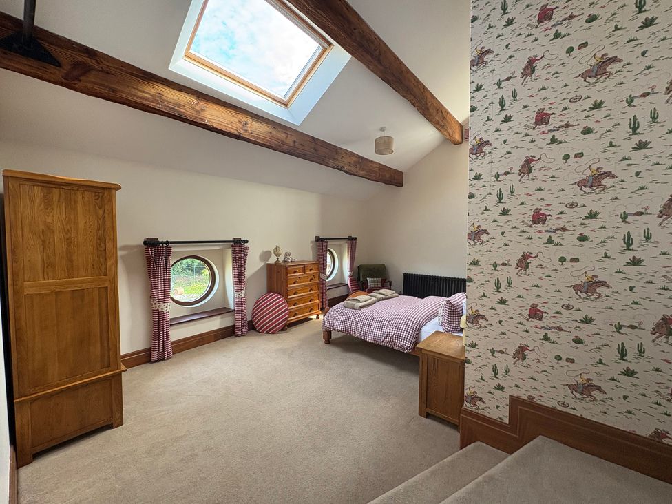 A bedroom with a bed and wardrobe at The Shippon in Burscough