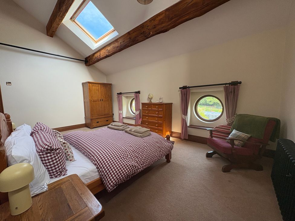 A bedroom with a bed and wardrobe at The Shippon in Burscough