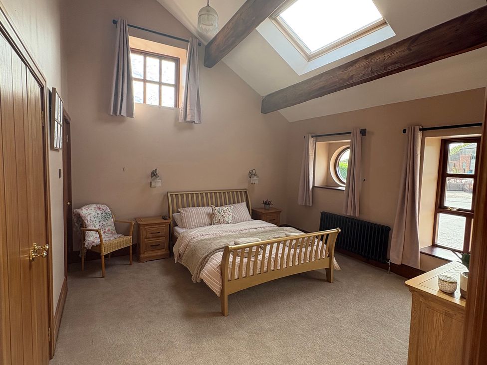 A bedroom with a bed and nightstand at The Shippon in Burscough
