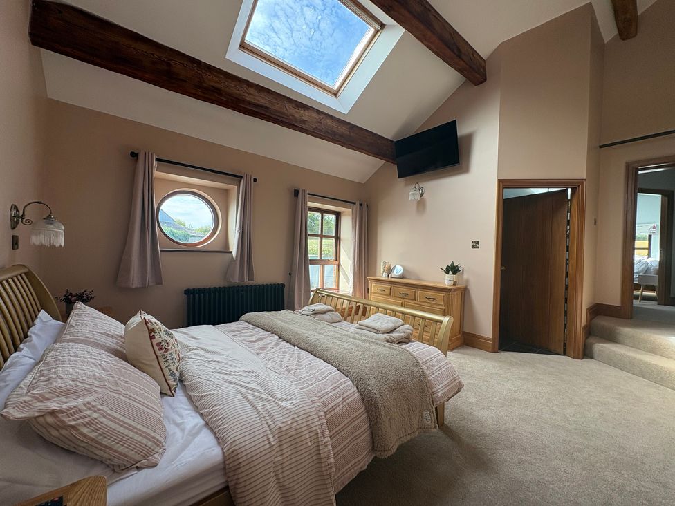 A bedroom with a bed and dresser at The Shippon in Burscough