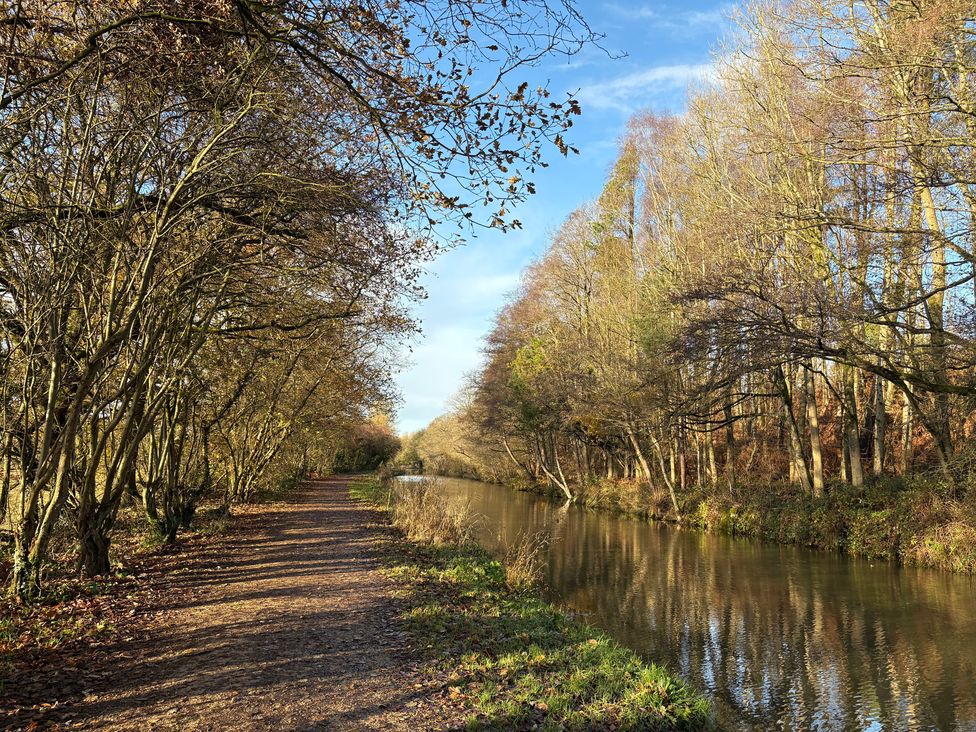 A canal with a path and trees beside it at The Shippon in Burscough