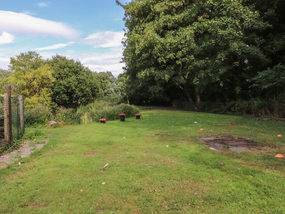 A garden with grass and trees at The Shippon in Burscough