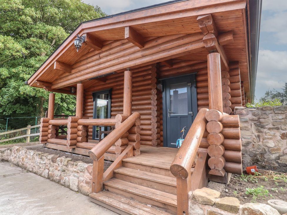 A log cabin with a porch and steps at The Log Cabin in Ormskirk
