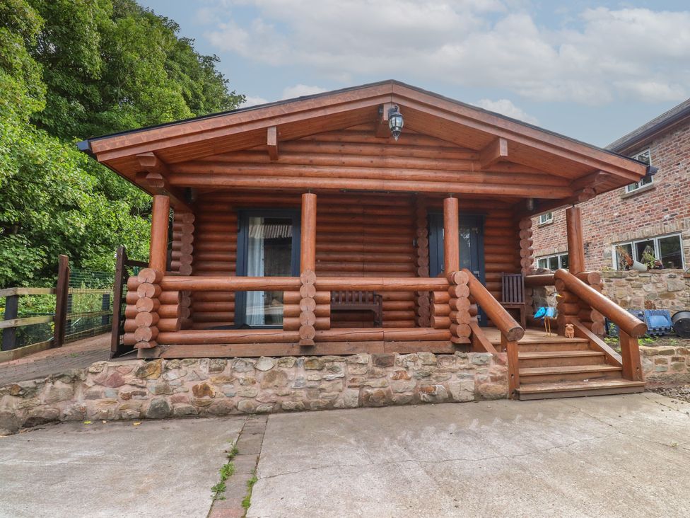 A log cabin with a porch and steps at The Log Cabin in Ormskirk