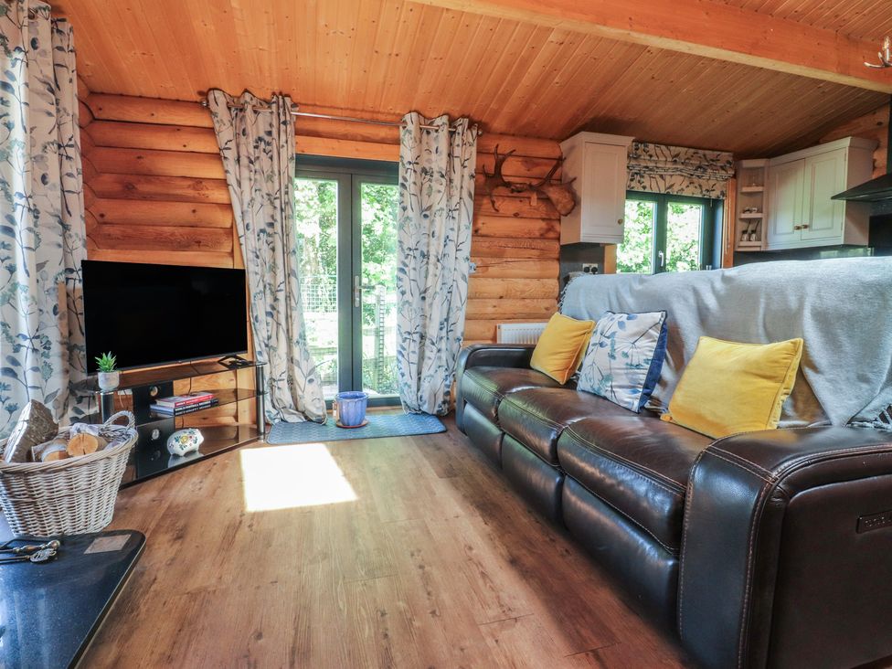 A living room with a sofa and television at The Log Cabin in Ormskirk