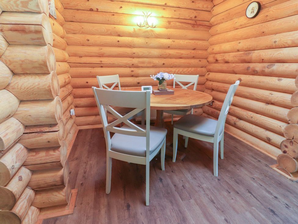 A dining room with a wooden table and chairs at The Log Cabin in Ormskirk