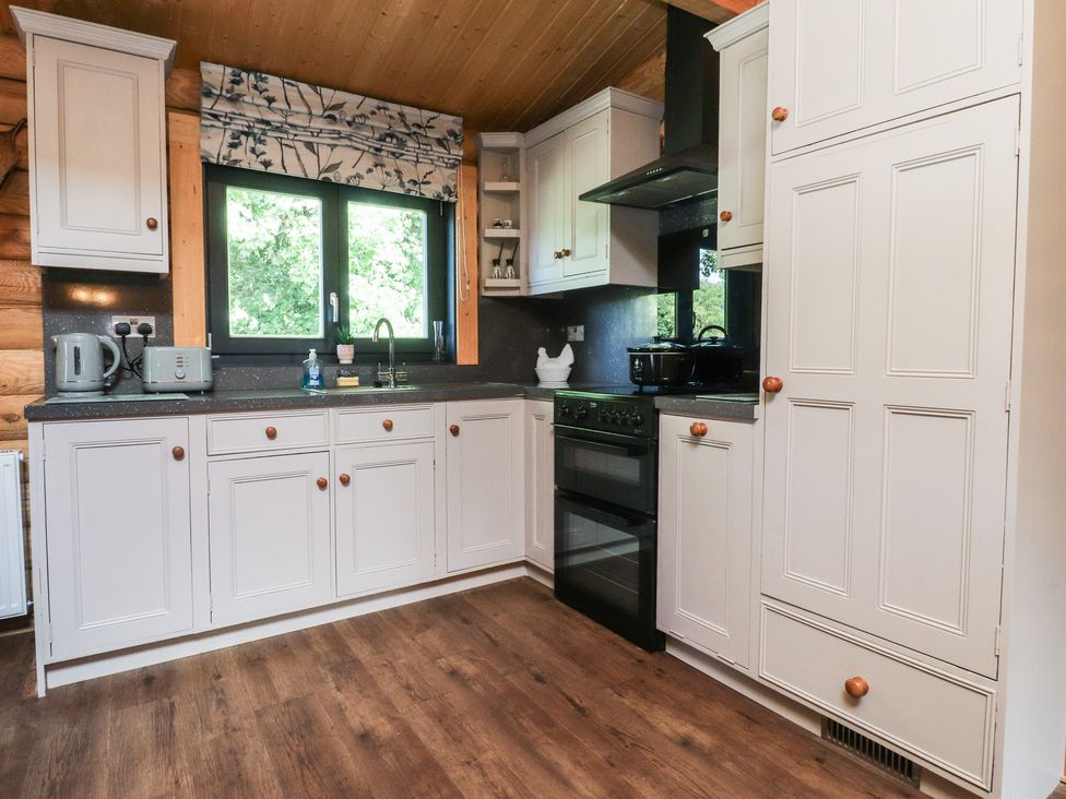 A kitchen with a sink and stove at The Log Cabin in Ormskirk