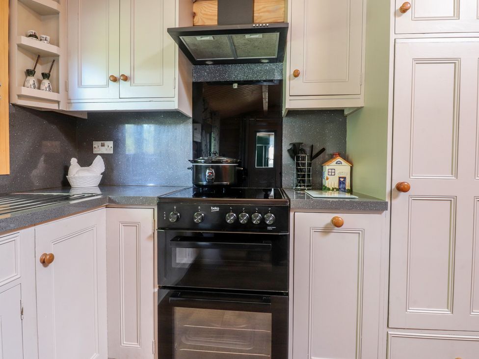 A kitchen with an oven and kitchen cabinets at The Log Cabin in Ormskirk
