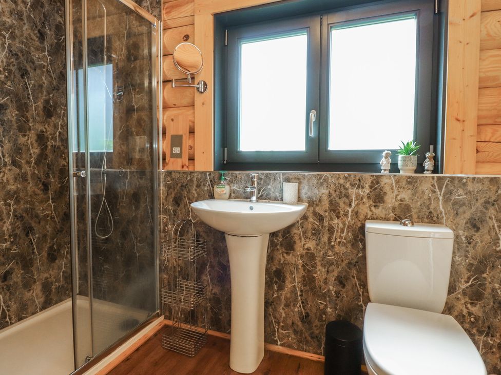 A bathroom with a shower, sink and toilet at The Log Cabin in Ormskirk