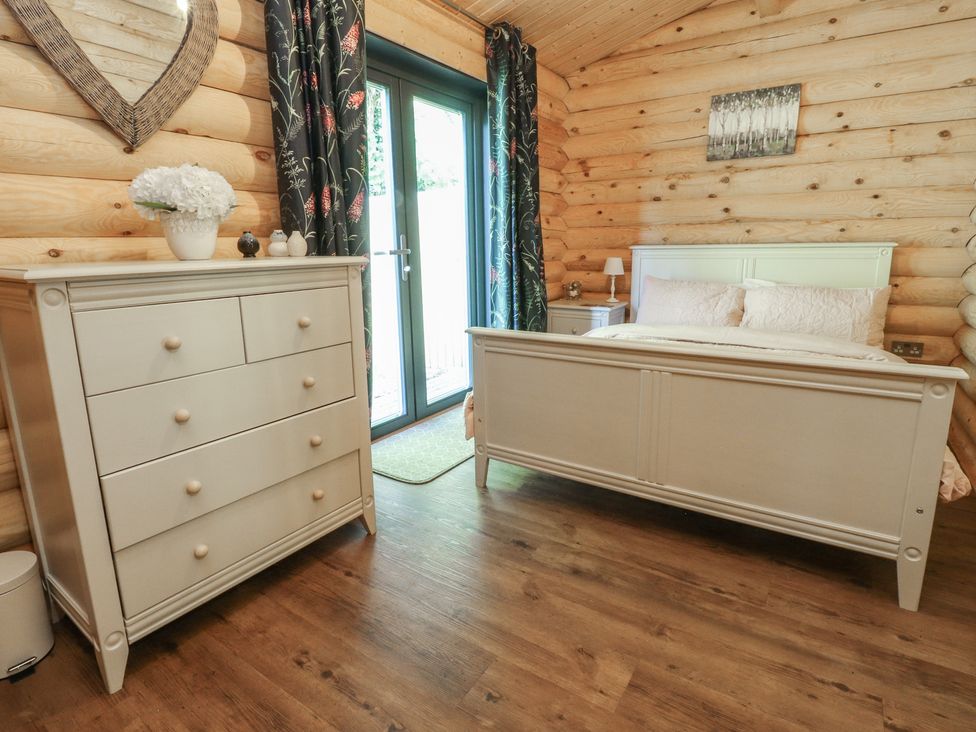 A bedroom with a bed and dresser at The Log Cabin in Ormskirk