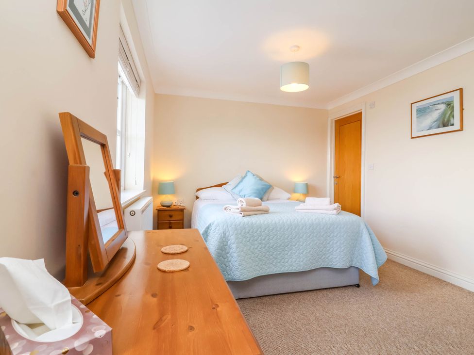 A bedroom with a bed and dresser at 1 Tideways in Bideford