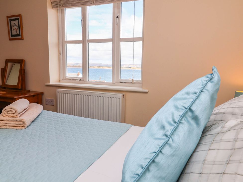 A bedroom with a bed and window view at 1 Tideways in Bideford