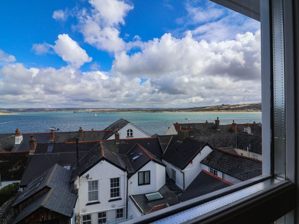 A view of rooftops and the sea with clouds at 1 Tideways in Bideford