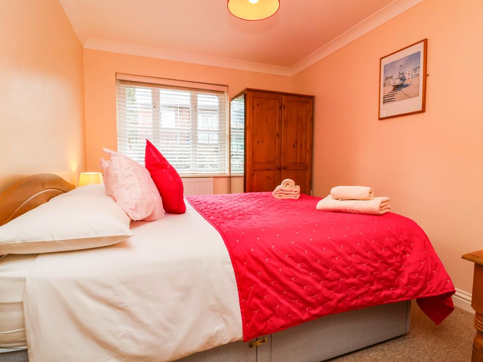 A bedroom with a bed and wardrobe at 1 Tideways Bideford