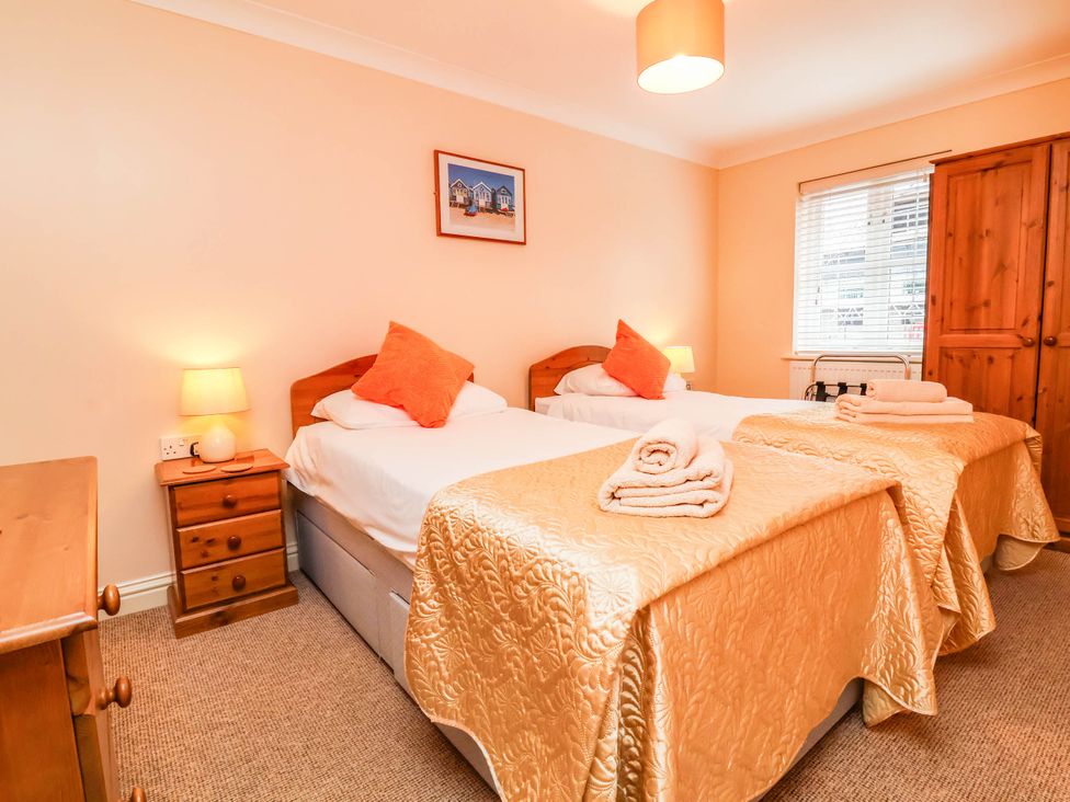 A bedroom with two beds and a wardrobe at 1 Tideways Bideford