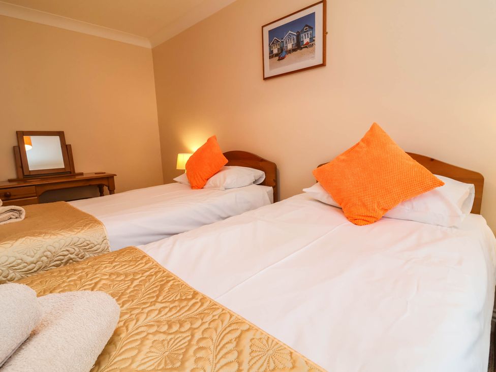 A bedroom with twin beds and a wooden table at 1 Tideways Bideford