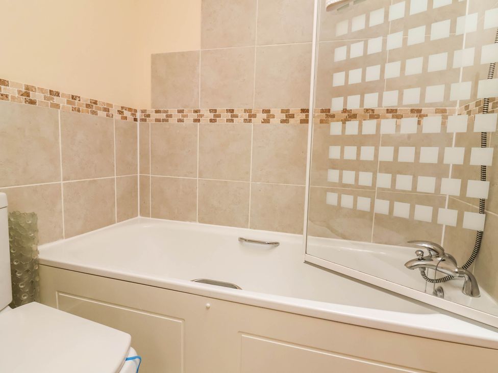 A bathroom with a bathtub and a toilet at 1 Tideways in Bideford