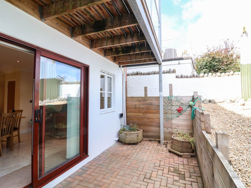 An outdoor area with a wooden deck and planters at 1 Tideways in Bideford