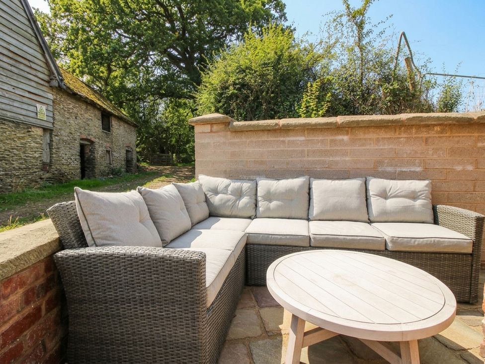 An outdoor seating area with a sofa and coffee table at Little Red Barn in Wallop near Westbury