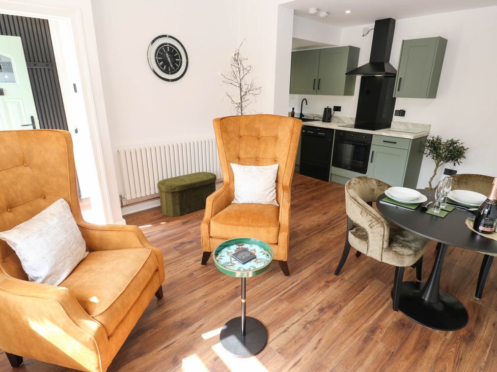 A kitchen with chairs and a dining table at Brodie Cottage in Brighouse
