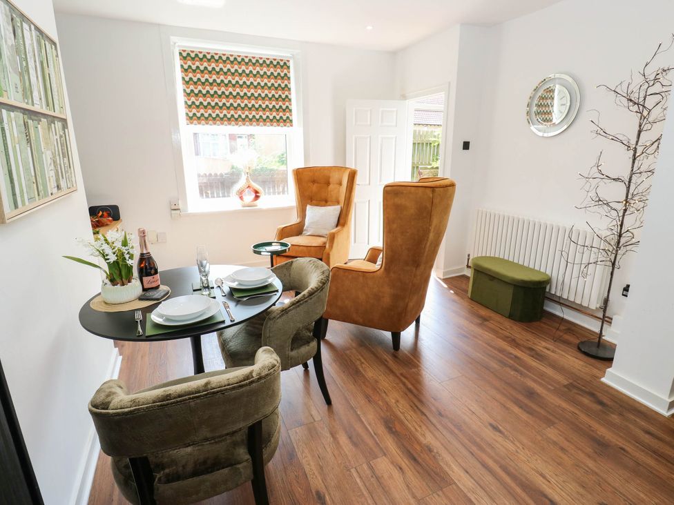 A dining room with a table set for meals at Brodie Cottage in Brighouse